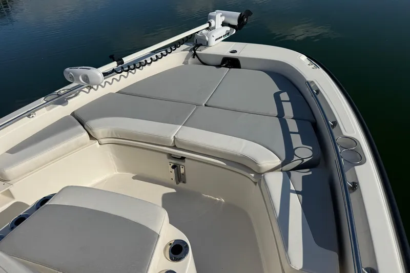 Slide: The Image of 2014 Boston Whaler 210 Dauntless boat interior with cushioned seating and fishing rod holders. - 11
