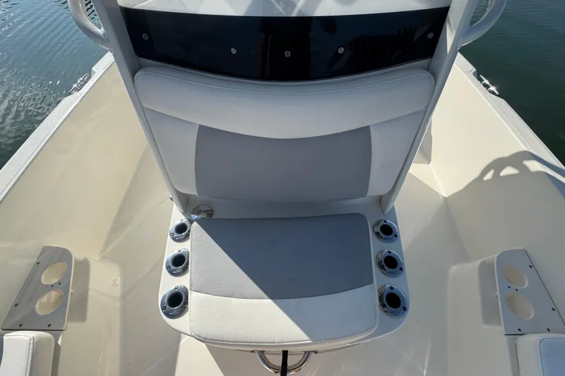 Slide: The Image of 2014 Boston Whaler 210 Dauntless boat seating area with cup holders, on calm water. - 15