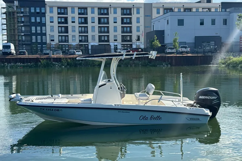 Slide: The Image of 2014 Boston Whaler 210 Dauntless boat on calm water near urban buildings. - 5