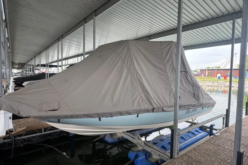 Slide: The Image of 2014 Boston Whaler 210 Dauntless boat covered and docked in a marina. - 9