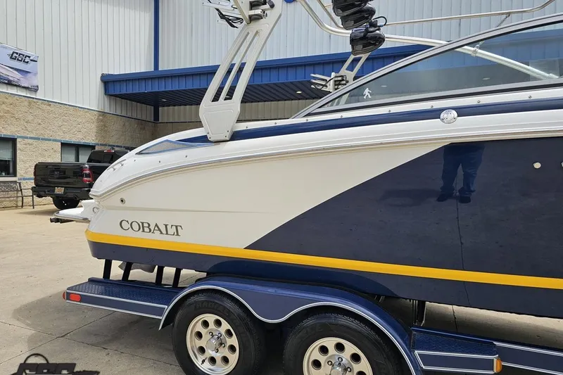 Slide: The Image of 2010 Cobalt 232 WSS boat on trailer, parked outside a building. - 10