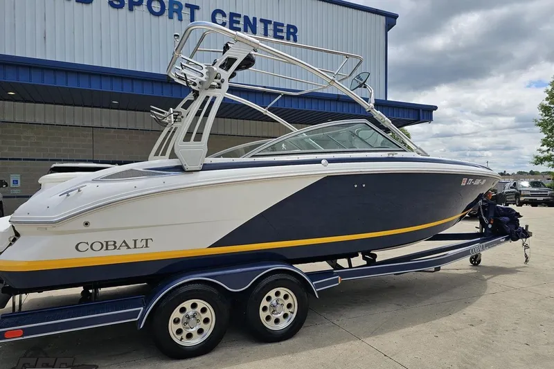 Slide: The Image of 2010 Cobalt 232 WSS boat on trailer outside a sport center. - 12
