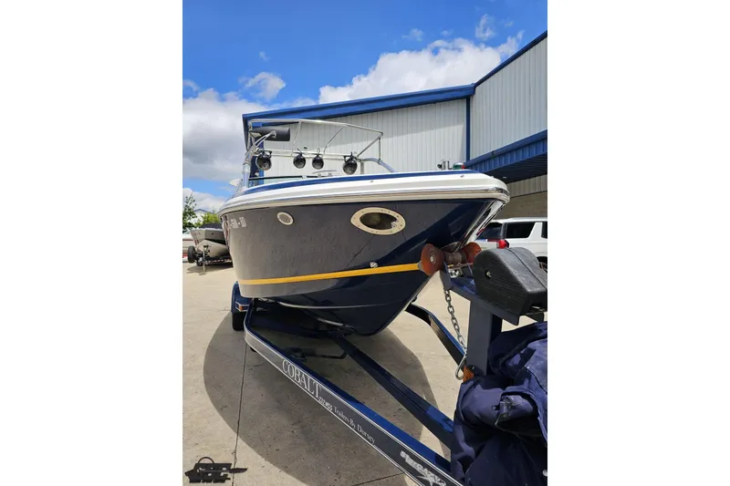 Slide: The Image of 2010 Cobalt 232 WSS boat on trailer, parked outdoors under blue sky. - 15