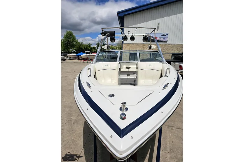 Slide: The Image of 2010 Cobalt 232 WSS boat with sleek design, parked outdoors under a cloudy sky. - 16