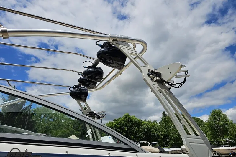 Slide: The Image of 2010 Cobalt 232 WSS boat with wakeboard tower against a cloudy sky. - 24