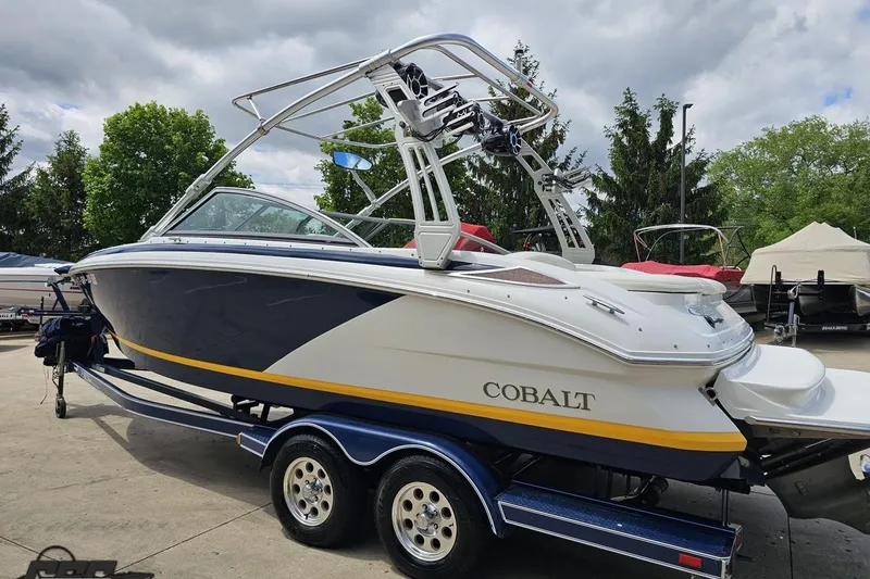 Slide: The Image of 2010 Cobalt 232 WSS boat on trailer, parked outdoors under cloudy sky. - 28