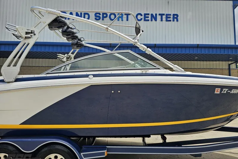 Slide: The Image of 2010 Cobalt 232 WSS boat at Grand Sport Center, featuring sleek design and wakeboard tower. - 3