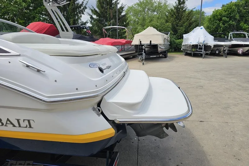 Slide: The Image of 2010 Cobalt 232 WSS boat with swim platform, parked among covered boats. - 30