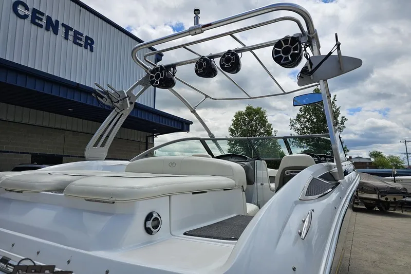 Slide: The Image of 2010 Cobalt 232 WSS boat with wakeboard tower and speakers, parked near a center. - 33