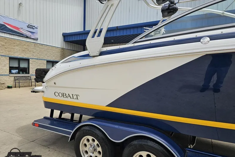 Slide: The Image of 2010 Cobalt 232 WSS boat on trailer, parked outside a building. - 4