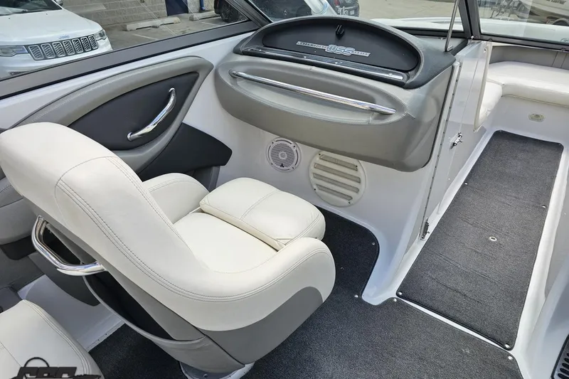 Slide: The Image of Interior of a 2010 Cobalt 232 WSS boat, featuring white seating and dashboard. - 54