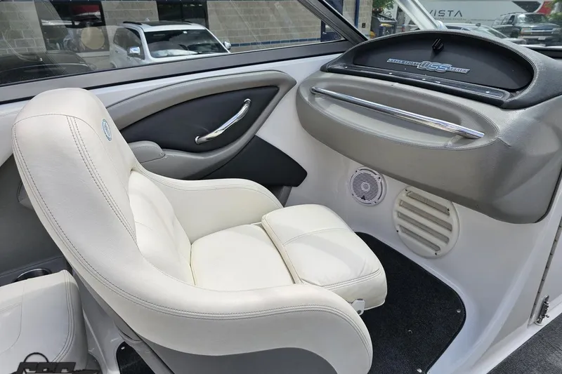 Slide: The Image of Interior of a 2010 Cobalt 232 WSS boat with white leather seating and sleek dashboard. - 55