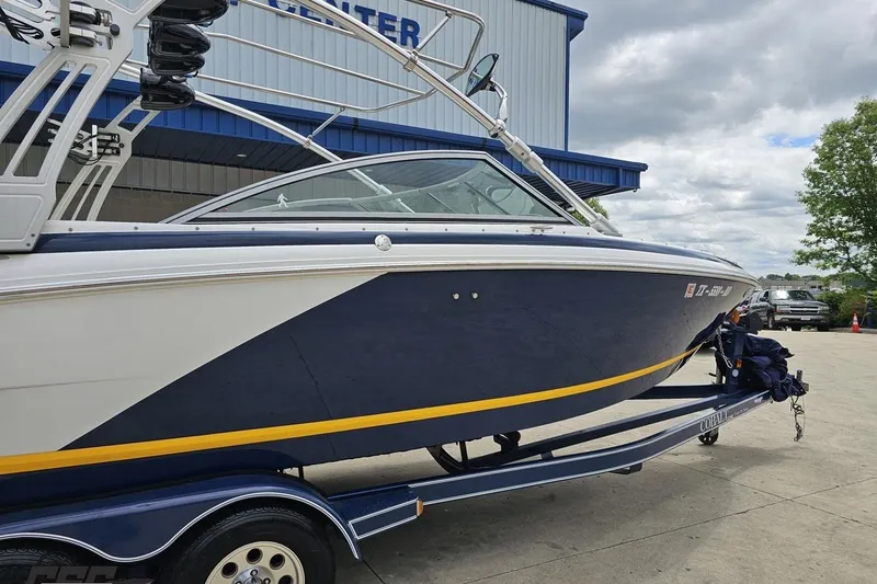 Slide: The Image of 2010 Cobalt 232 WSS boat on trailer, parked outdoors near a building. - 6
