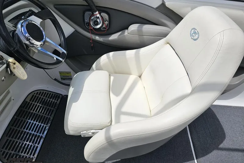 Slide: The Image of 2010 Cobalt 232 WSS boat interior with white captain's chair and steering wheel. - 61