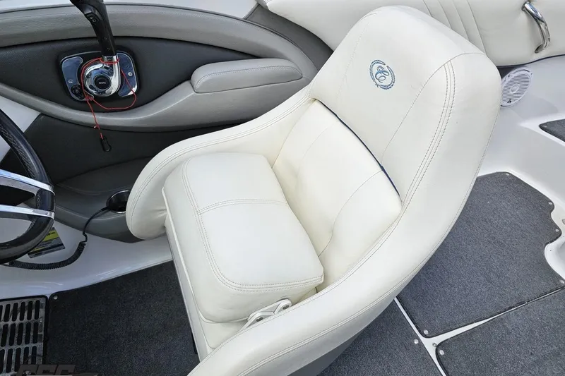 Slide: The Image of 2010 Cobalt 232 WSS boat interior with white leather captain's chair and steering wheel. - 62