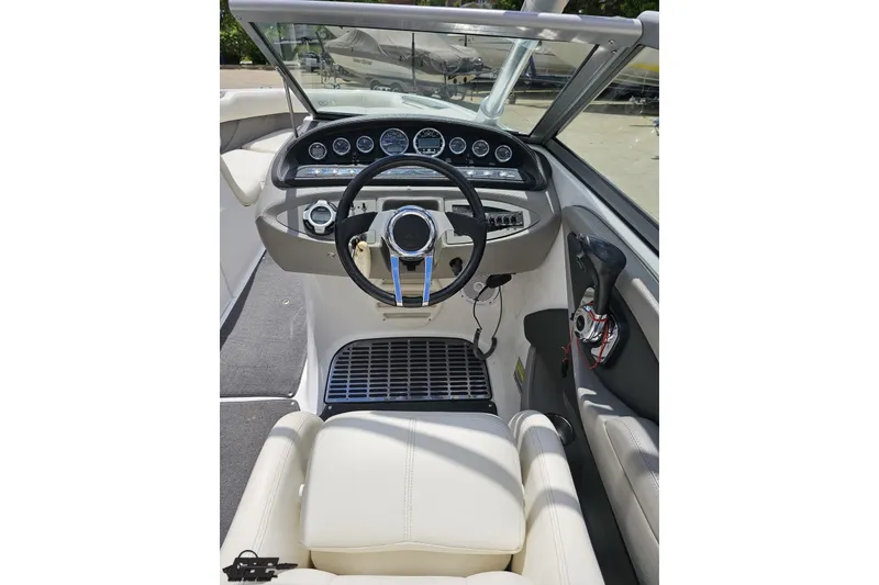 Slide: The Image of Cockpit of 2010 Cobalt 232 WSS boat with steering wheel and dashboard controls. - 63