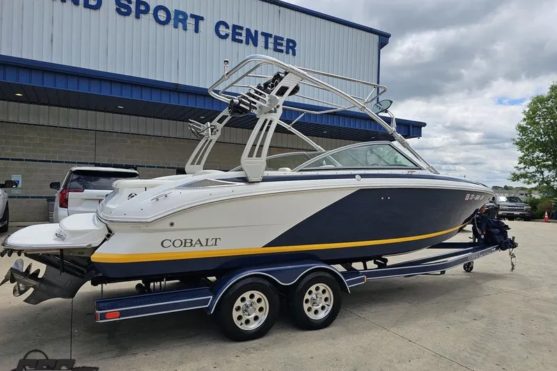 Slide: The Image of 2010 Cobalt 232 WSS boat on trailer outside a sports center. - 7