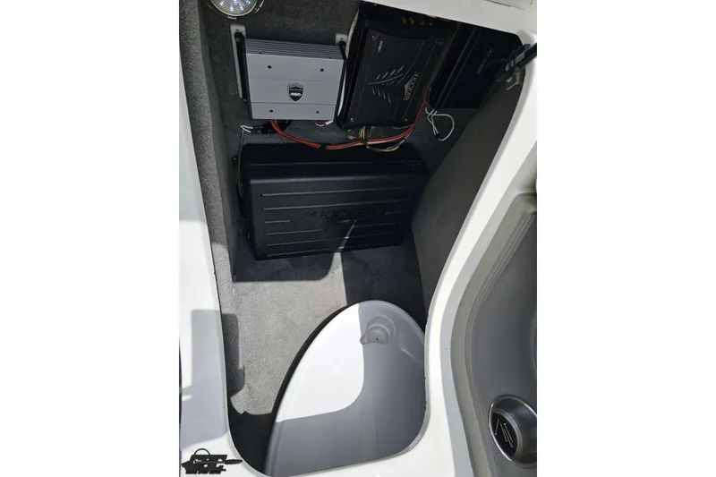 Slide: The Image of 2010 Cobalt 232 WSS boat interior showing audio equipment and storage compartment. - 78