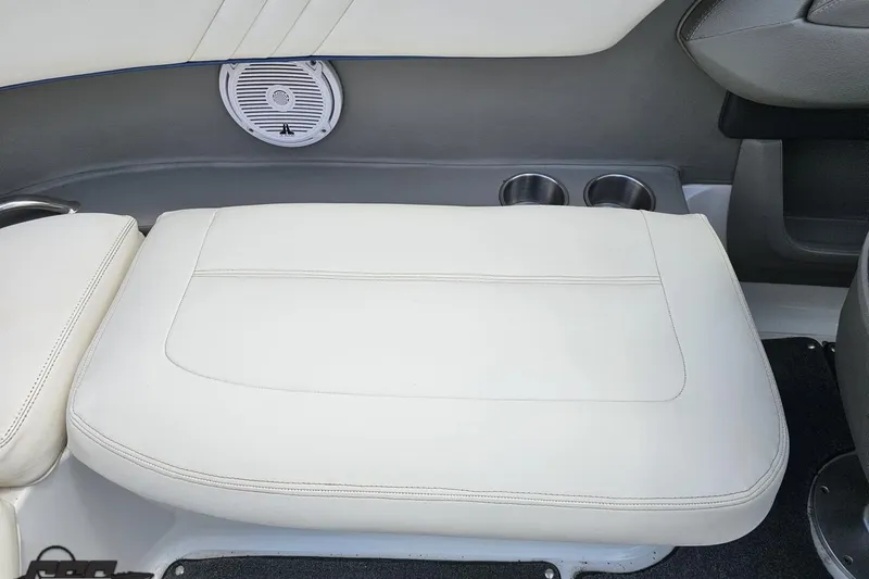 Slide: The Image of 2010 Cobalt 232 WSS boat interior with white cushioned seating and built-in cup holders. - 89