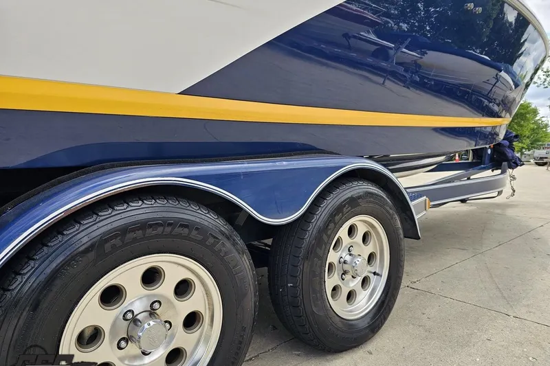 Slide: The Image of 2010 Cobalt 232 WSS boat on trailer, featuring dual radial tires and sleek blue design. - 9