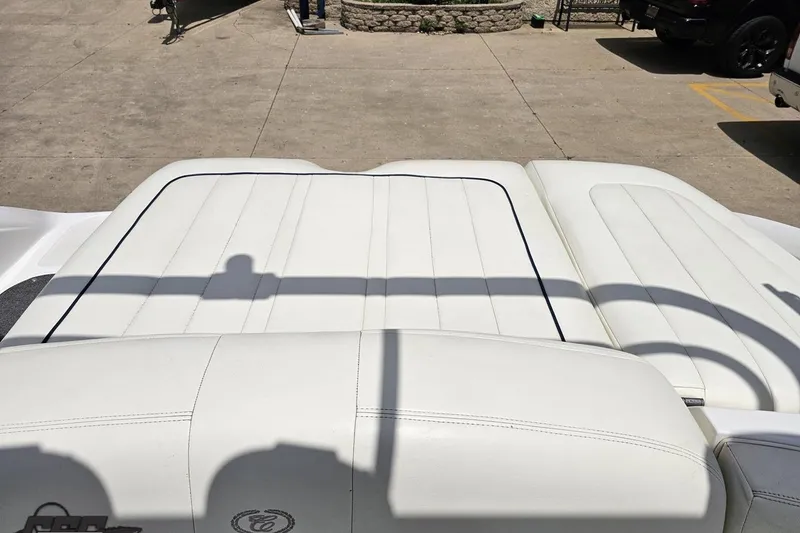 Slide: The Image of White leather seating on a 2010 Cobalt 232 WSS boat, parked on concrete. - 95