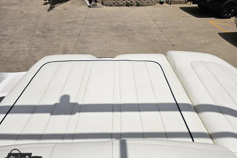 Slide: The Image of 2010 Cobalt 232 WSS boat with white cushioned seating, outdoor setting. - 96