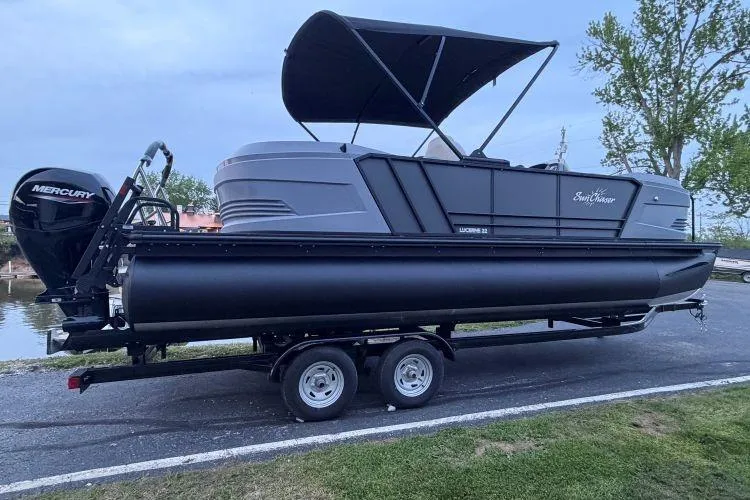 The Image of 2026 SunChaser Lucerne 22 LR DH Sport pontoon boat on trailer, with Mercury outboard motor. - 0