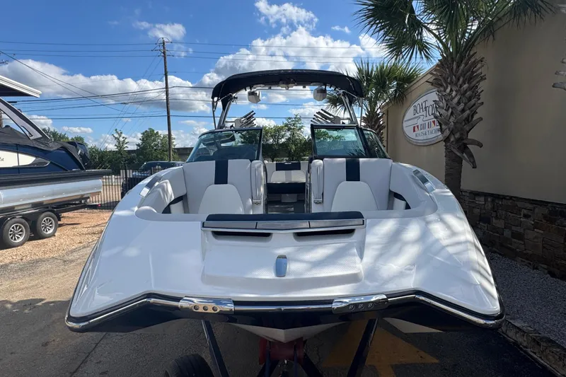 Slide: The Image of 2019 MasterCraft X24 boat with sleek design, parked outdoors under a blue sky. - 4