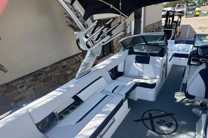 Slide: The Image of 2019 MasterCraft X24 boat interior with white and navy seating, sleek design, and modern features. - 8