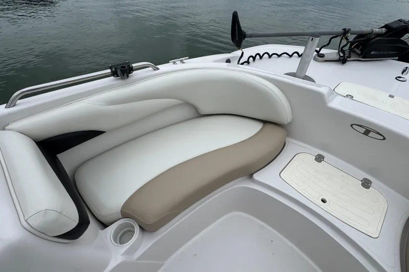 Slide: The Image of 2017 Tahoe 195 boat interior with white and beige seating by the water. - 15