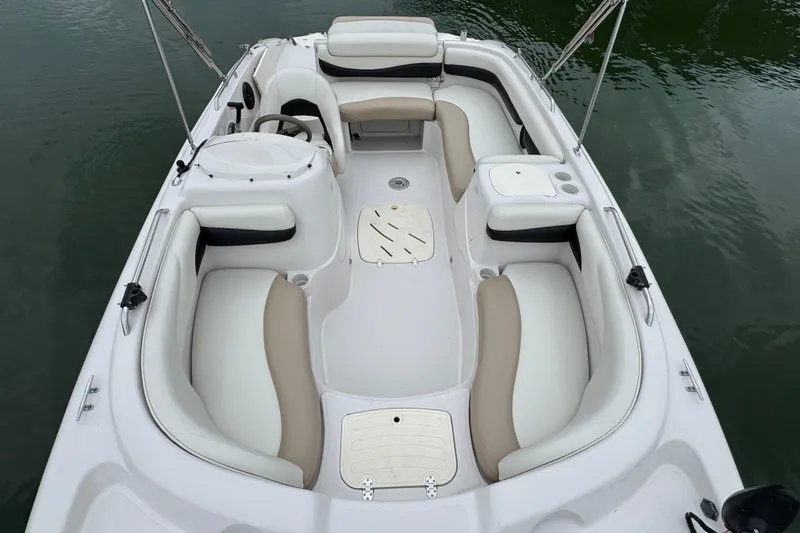 Slide: The Image of 2017 Tahoe 195 boat interior with white and beige seating on calm water. - 17