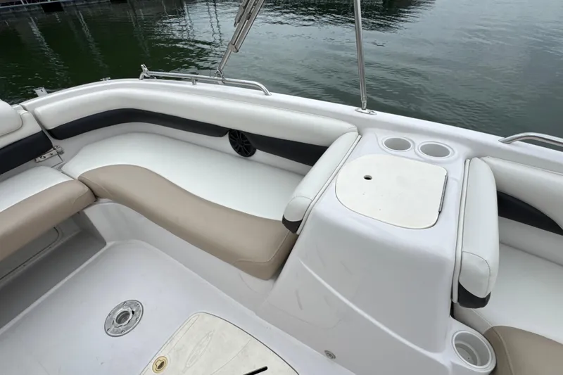 Slide: The Image of 2017 Tahoe 195 boat interior with beige seating and cup holders by the water. - 18