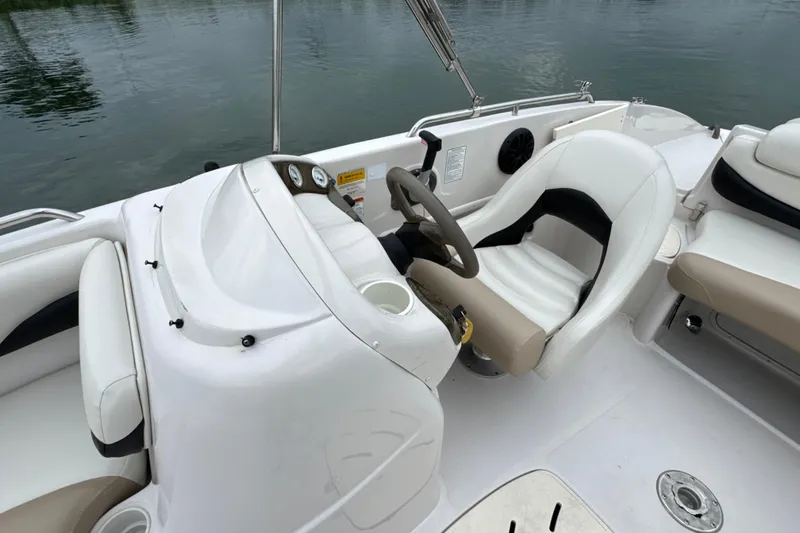 Slide: The Image of 2017 Tahoe 195 boat interior with white and beige seating, steering wheel, and dashboard. - 19