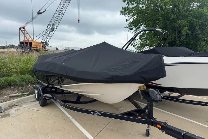 Slide: The Image of Covered 2017 Tahoe 195 boat on trailer, parked near construction site. - 9