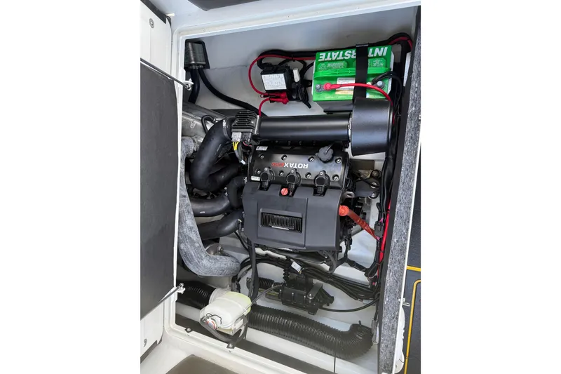 Slide: The Image of Engine compartment of 2026 Highfield Velox 560 boat, featuring Rotax engine and battery setup. - 13