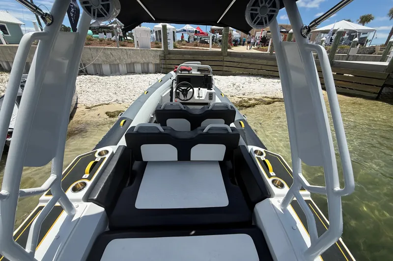Slide: The Image of 2026 Highfield Velox 560 boat docked by sandy shore, showcasing interior seating and controls. - 7