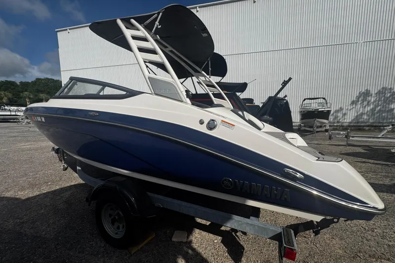 Slide: The Image of 2021 Yamaha Boats 195S in blue and white, parked outdoors on a trailer. - 7