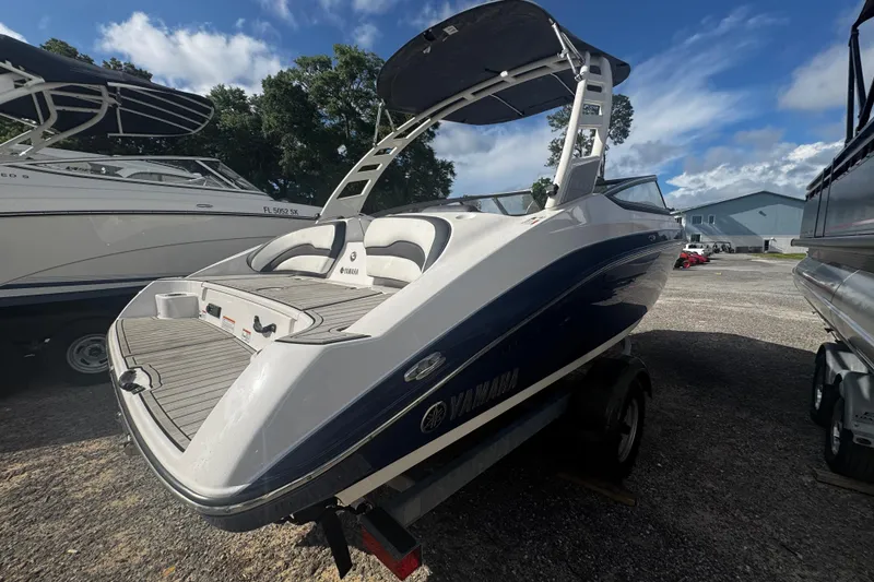 Slide: The Image of 2021 Yamaha Boats 195S with sleek design, parked outdoors under a clear sky. - 9