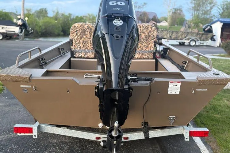 Slide: The Image of 2026 Smoker Craft Sportsman 1660 boat with powerful outboard motor, parked on a trailer. - 2