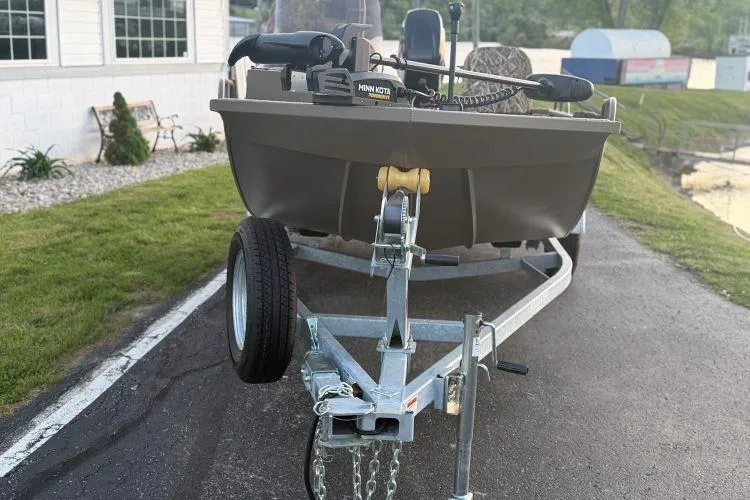 Slide: The Image of 2026 Smoker Craft Sportsman 1660 boat on trailer, equipped with Minn Kota motor. - 3