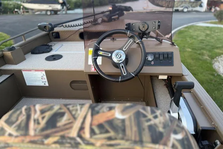 Slide: The Image of 2026 Smoker Craft Sportsman 1660 boat interior with steering wheel and control panel. - 5