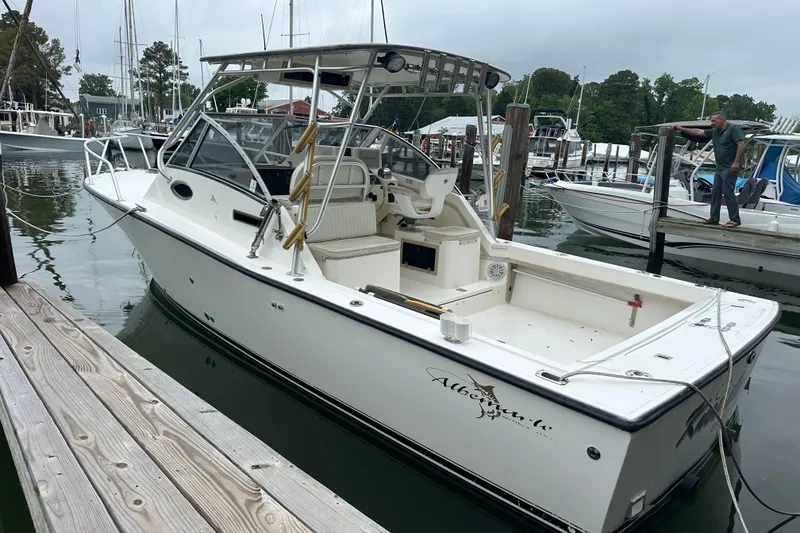 Slide: The Image of 2000 Albemarle 280 Express Fisherman boat docked at a marina, featuring spacious deck and cabin. - 30