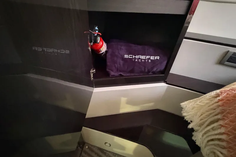 Slide: The Image of Cabinet interior of 2023 Schaefer 400 yacht with fire extinguisher and branded towel. - 10