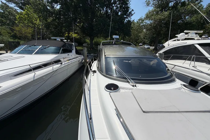 Slide: The Image of 2023 Schaefer 400 yacht docked between two other boats, surrounded by trees. - 34