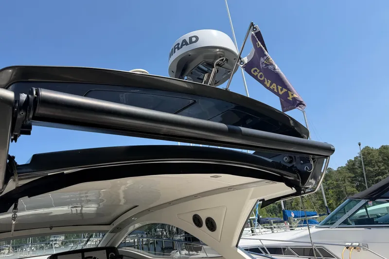 Slide: The Image of Schaefer 400 yacht, 2023 model, with radar and flag, docked under clear blue sky. - 38