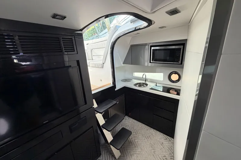 Slide: The Image of Modern Schaefer 400 yacht interior with kitchenette, microwave, and sleek black cabinetry, 2023 model. - 4