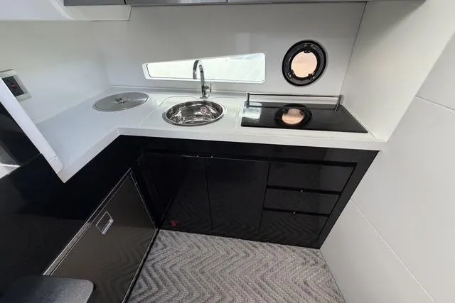 Slide: The Image of Modern kitchen in 2023 Schaefer 400 yacht with sleek black cabinetry and compact design. - 6