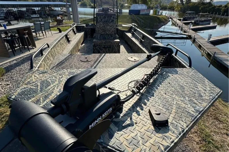 Slide: The Image of 2026 Smoker Craft Sportsman 1866 boat with Minn Kota trolling motor at a marina. - 2