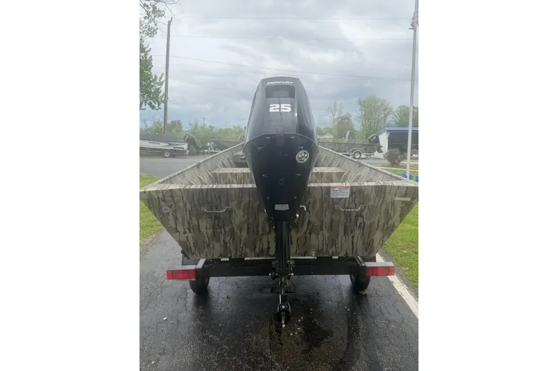 Slide: The Image of 2026 Smoker Craft 1448 Jon boat with Mercury 25 engine, parked on a trailer. - 2