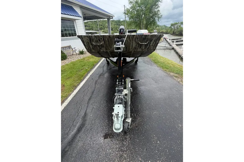 Slide: The Image of 2026 Smoker Craft 1448 Jon boat on trailer, parked near a marina. - 3